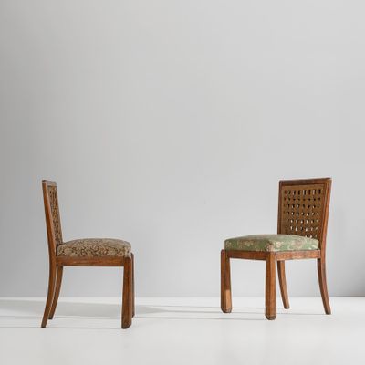 deux chaises en bois avec des assises rembourrées dans une pièce blanche