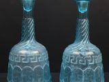 deux vases en verre bleu posés sur une table noire