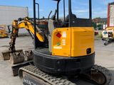 the back end of a small excavator parked in a parking lot