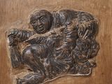une sculpture représentant un homme et un enfant sur une porte en bois