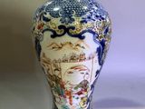 a blue and white vase with a picture of people on it