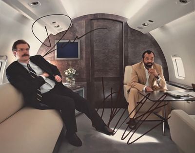 deux hommes assis sur un canapé dans un jet privé