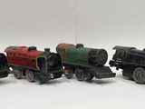 several toy trains are lined up in a row on a white surface
