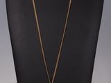 un collier avec une croix en or sur un mannequin
