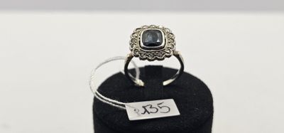 un gros plan d'une bague en argent sertie d'une pierre noire