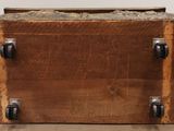 an old wooden box with metal handles on the floor