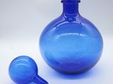 a blue glass bottle and a small blue glass bottle