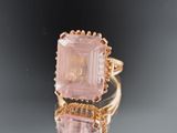 an image of a pink stone ring on a reflective surface
