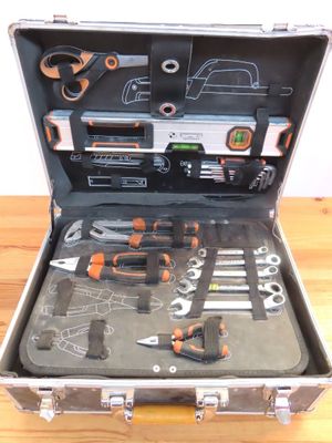 une mallette à outils contenant des outils, posée sur une table en bois