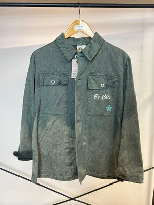chemise grise avec des étoiles vertes sur la poitrine et le torse