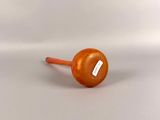 an orange plastic ball with a stick sticking out of it