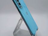 a close up of a cell phone on a stand on a white surface