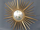 un miroir doré en forme d'étoile accroché au mur
