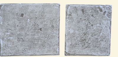 two pieces of stone with a drawing of a boat on it