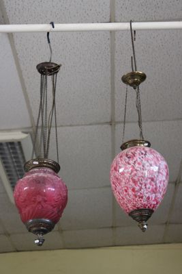 trois lampes roses suspendues au plafond dans une pièce
