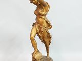 bronze figurine of a woman holding a bird on a pedestal