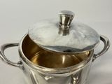 a silver pot with a lid sitting on a table