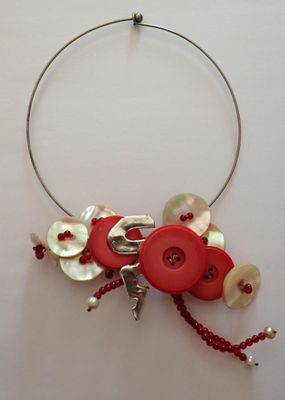 un collier composé de boutons et de perles sur un fond blanc