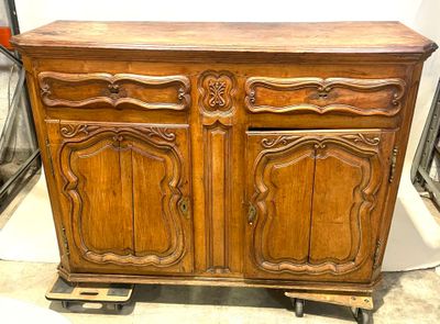 une armoire en bois posée sur des roulettes dans une pièce