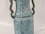a blue vase with a handle on a white background