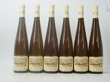 six bouteilles de vin sont alignées sur une table