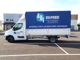 un camion garé sur un parking, avec une pancarte à l'arrière