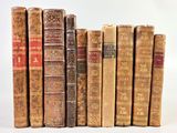 plusieurs vieux livres sont alignés sur une surface blanche