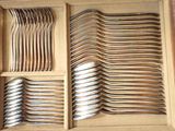many forks and spoons in a box on the table