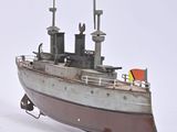 a small model of a boat on a white surface