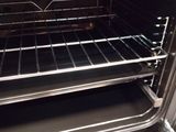 an open oven with a rack in the middle of it