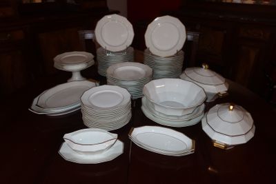 beaucoup d'assiettes et de bols blancs sur une table
