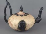 a black and white teapot on a gray surface