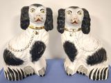 pair of black and white dog figurines sitting on blue cloth