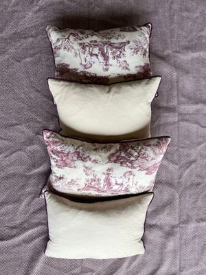 three pillows are stacked on top of each other on a bed