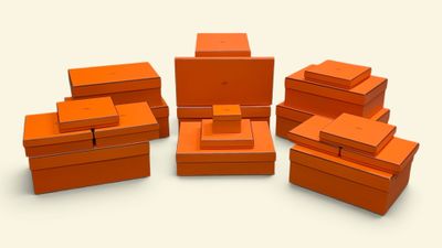 Plusieurs boîtes orange sont empilées les unes sur les autres sur une surface blanche