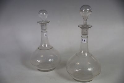 pair of clear glass decanters on a white surface