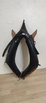 un gant en cuir noir posé sur un parquet