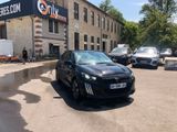 a black car parked in front of a building with a no parking sign