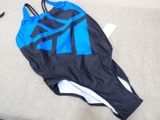 a blue and black one piece swimsuit laying on a couch