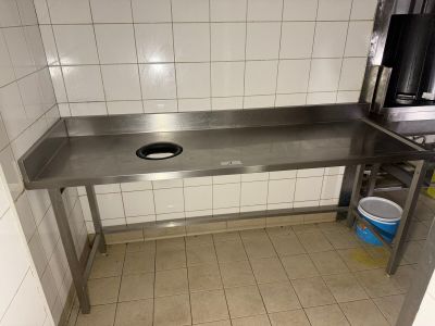 a stainless steel table with a sink in a kitchen
