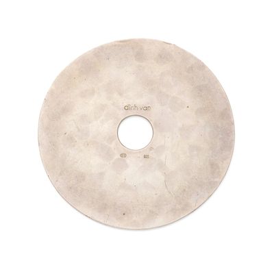 un disque blanc percé d'un trou, posé sur une surface blanche