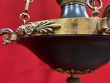 a black and gold lamp hanging from a chain