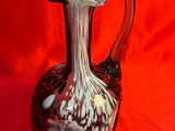 un vase en verre posé sur un tissu rouge