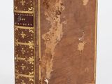 un vieux livre posé sur une surface blanche