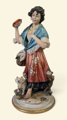 une figurine représentant une femme tenant un oiseau et un chien