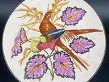 a plate with a bird and flowers painted on it