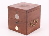 a small wooden box with two drawers on it