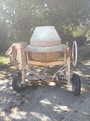 a cement mixer sitting on a trailer in the dirt