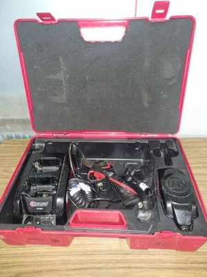 une mallette rouge contenant deux postes de radio, posée sur une table en bois