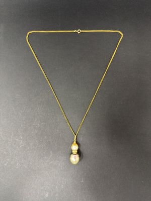 a gold necklace with a pearl pendant hanging from it